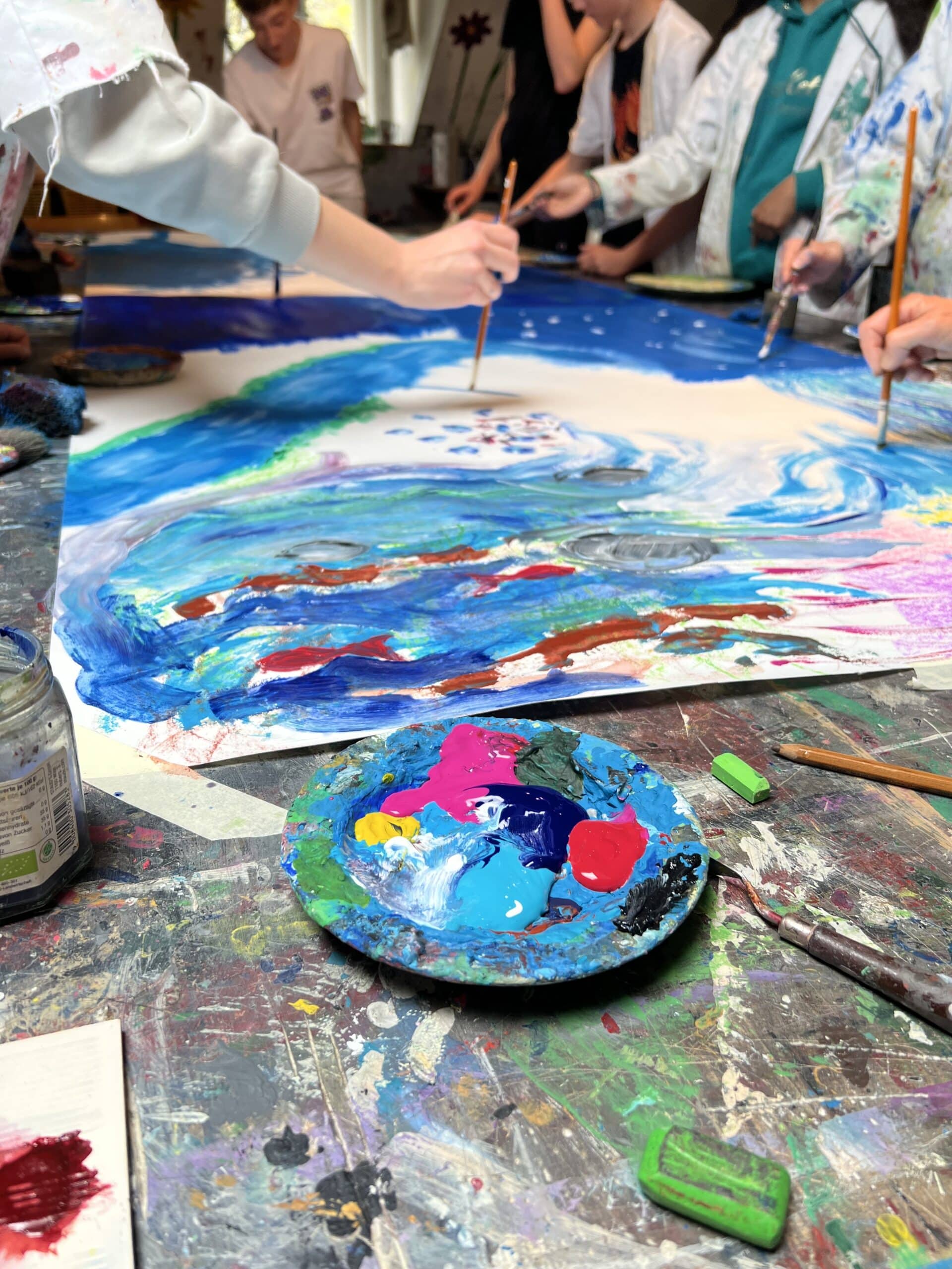 Schüler arbeiten mit Acrylfarben